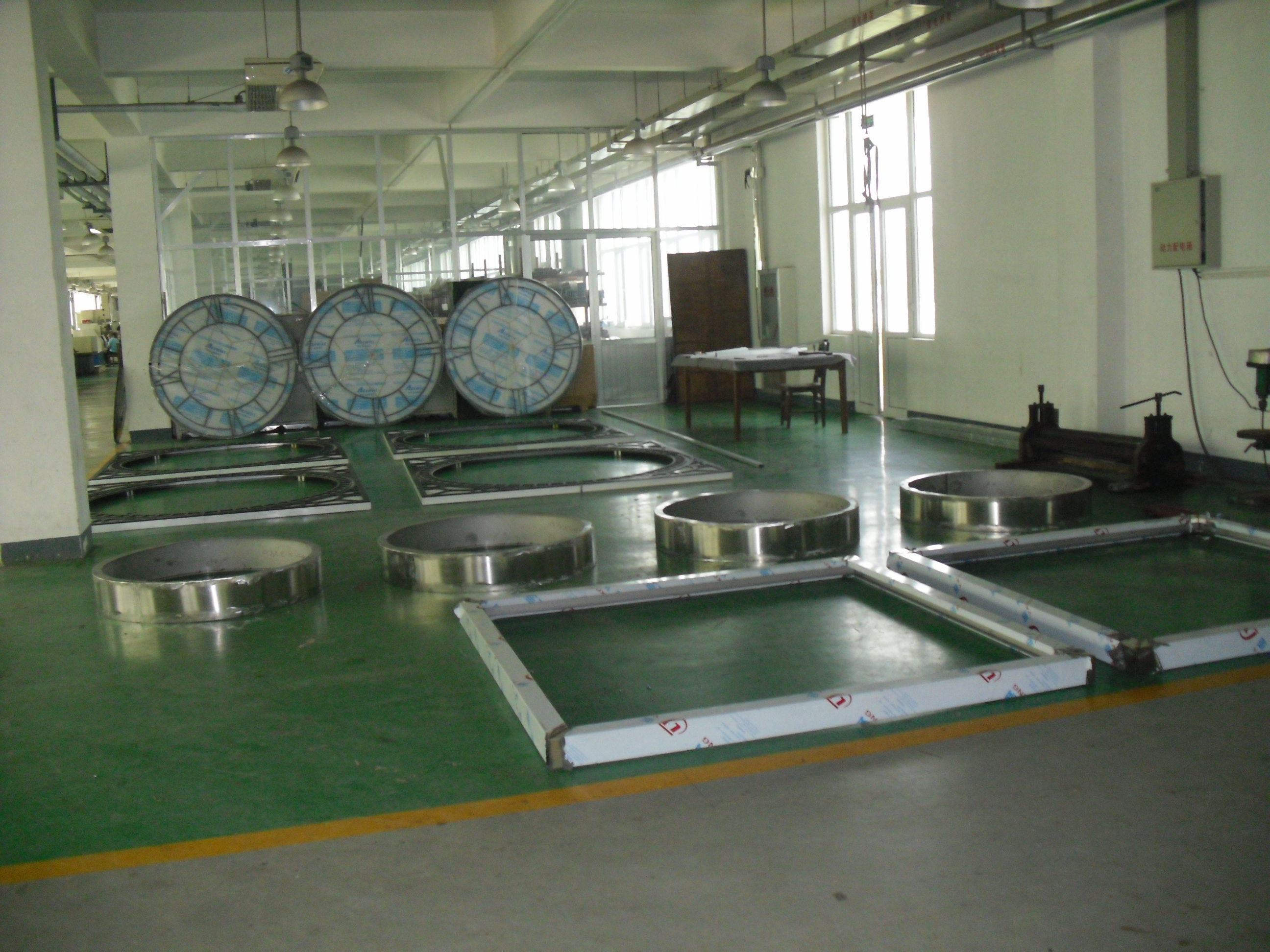 Clock-face rings and finished dials arranged across the production floor.